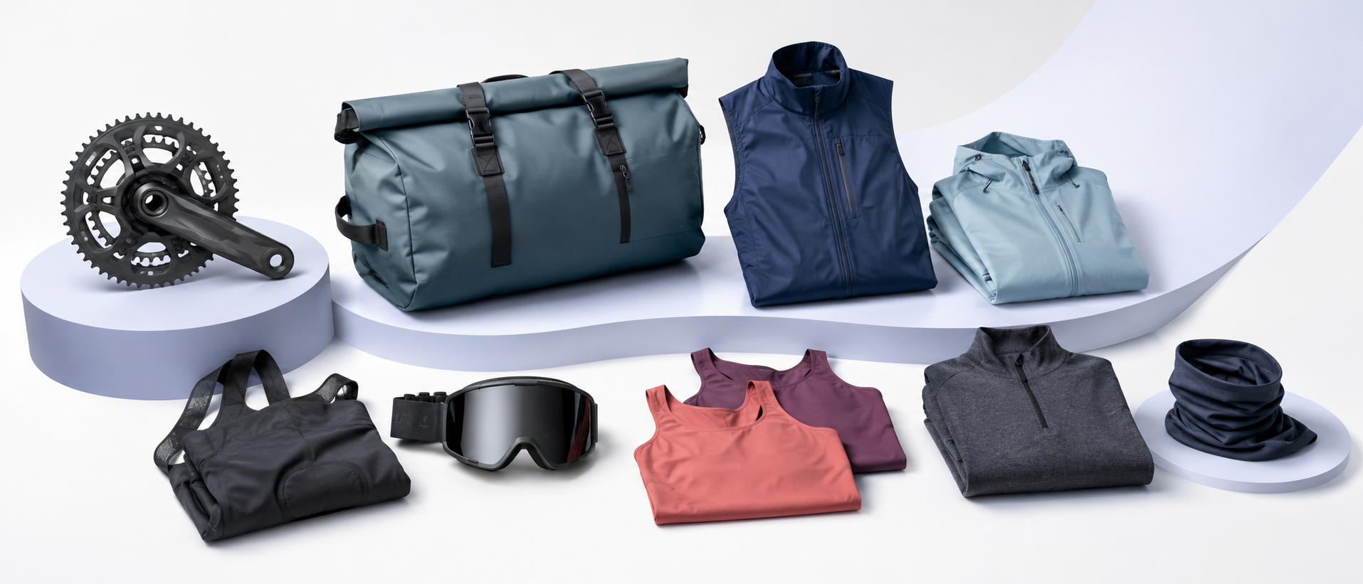 Cycling components, a travel duffel, outdoor layers, goggles, and accessories in a white studio